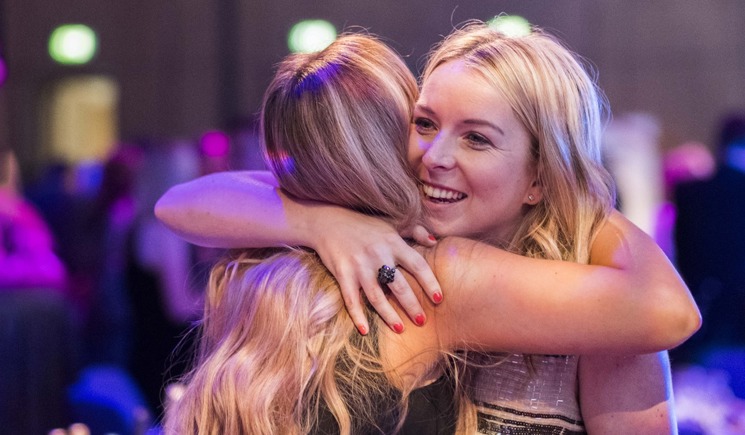 Two women hugging at an event