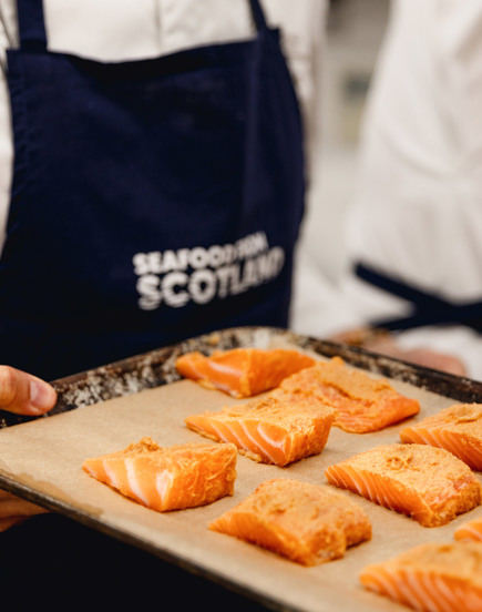 Tray of salmon held by chef