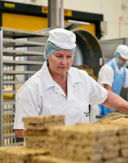 woman in factory with hairnet and white coat