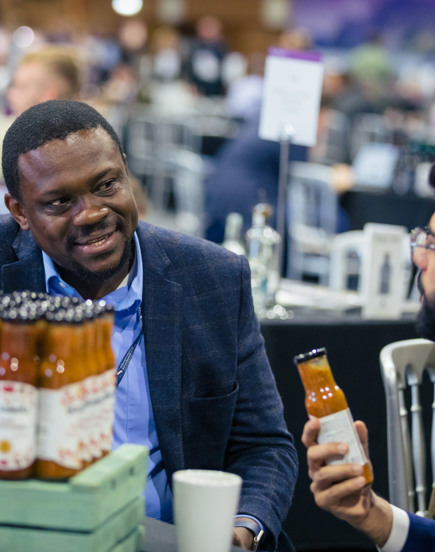 man holding sauce bottle looking at another man